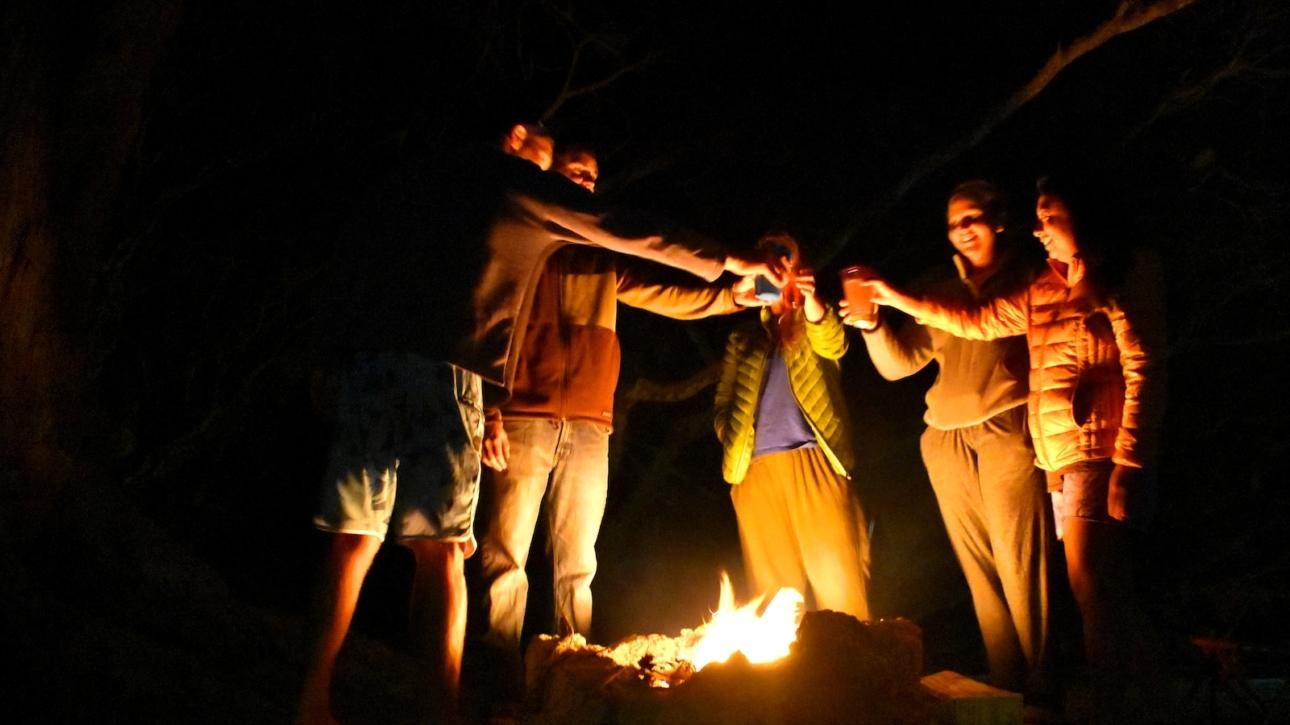 group of people standing in front of bonfire